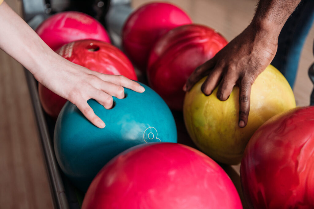 Två personer väljer bowlingklot inför en omgång tillsammans